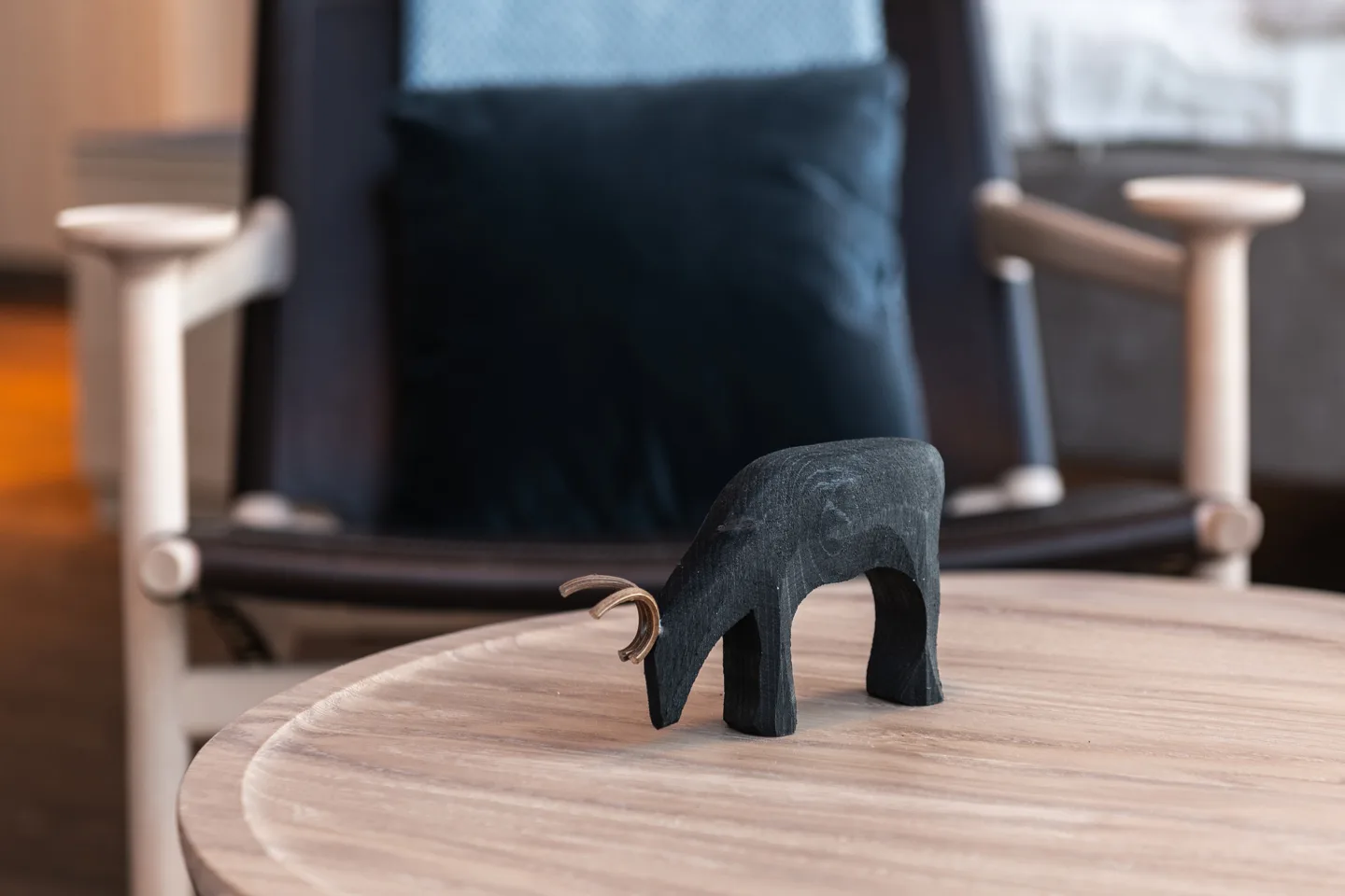 Small wooden reindeer figurine with wire antlers on a coffee table in a Nordic hotel room