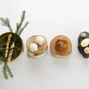 Nordic-style appetizers including breadsticks on spruce, pastries on birch wood and flavored butters on stone